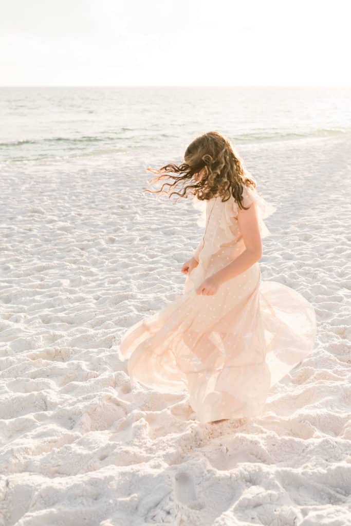 girl twirling on the beach
