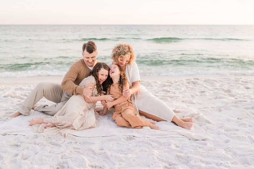 parents tickling their two daughters at the beach by Andrea Krey, one of Destin Florida photographers