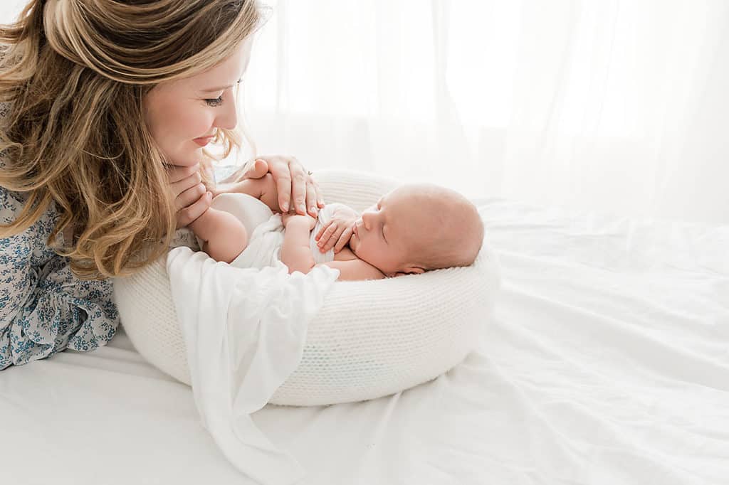 beautiful woman holding her newborns hand