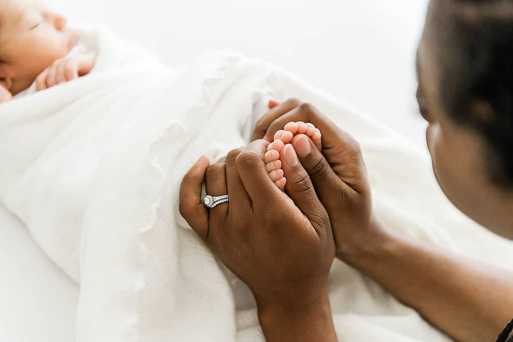 a mom holding her newborns feet