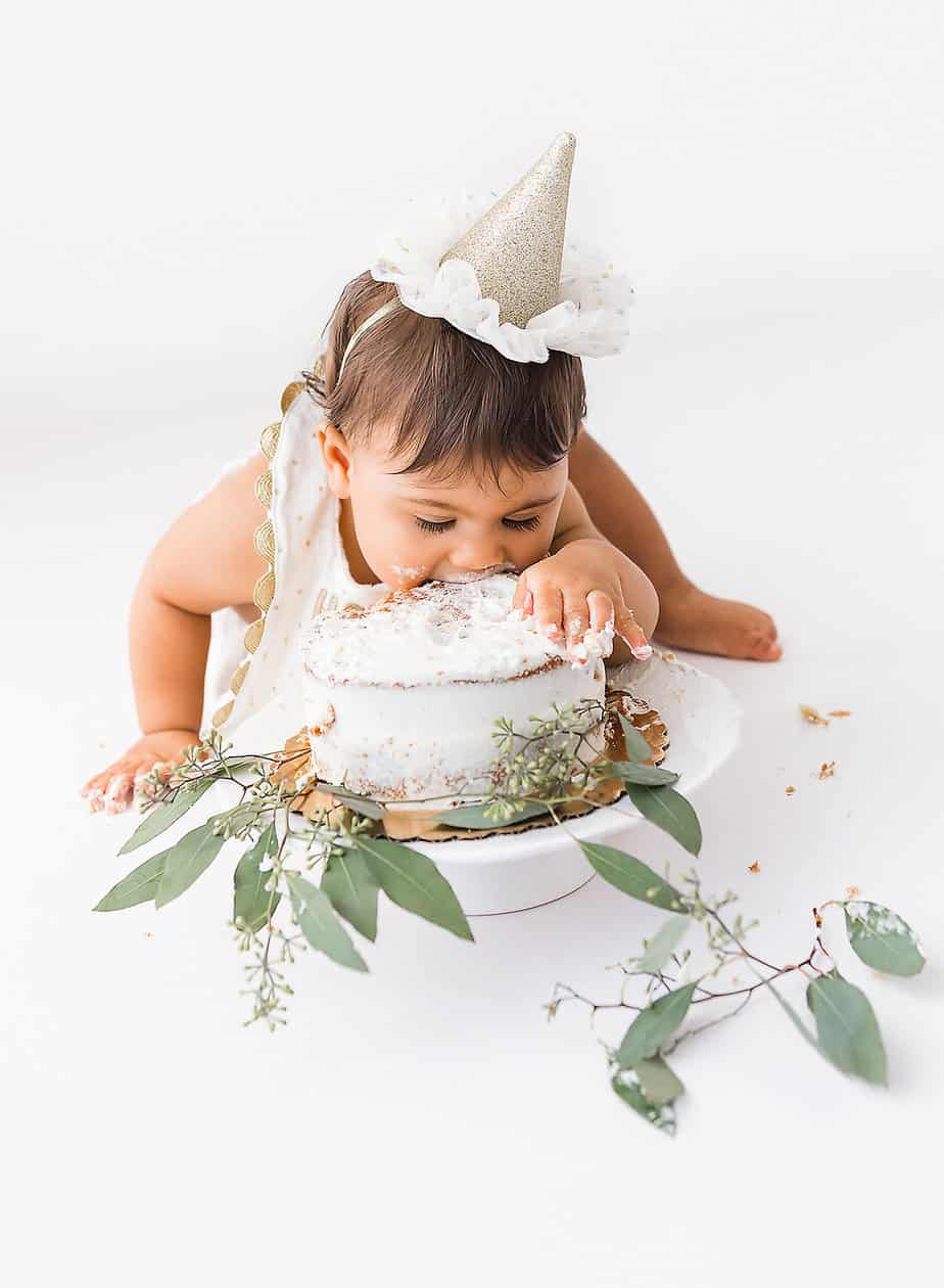 cute baby taking a bite out of her cake