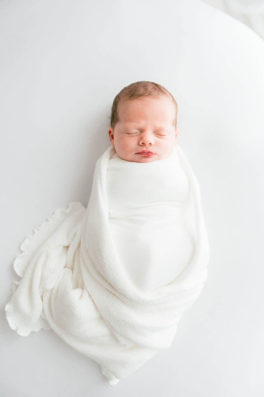 newborn girl in white wrap