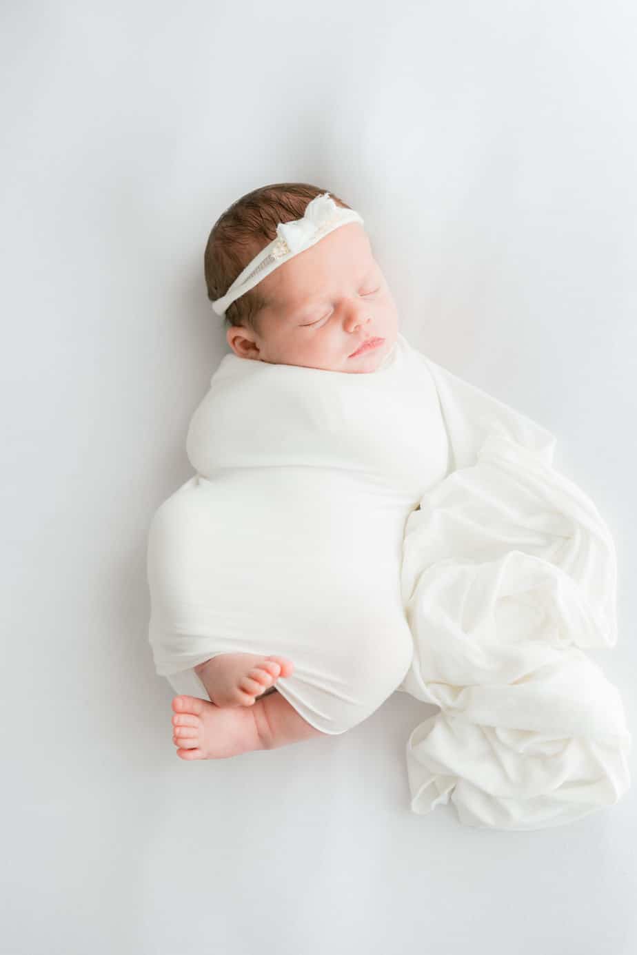 a newborn wrapped in a white wrap