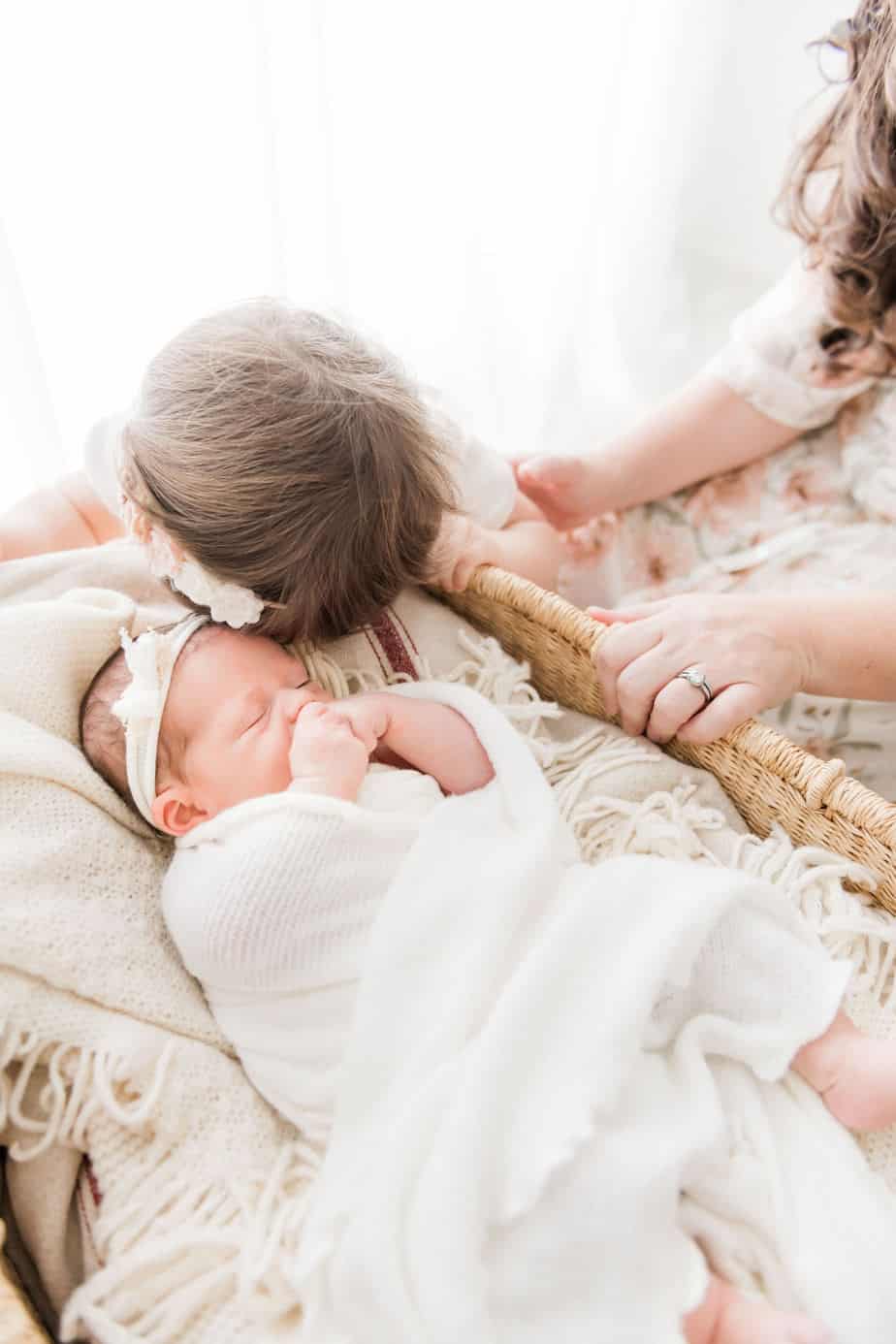 a toddler kissing her newborn sister