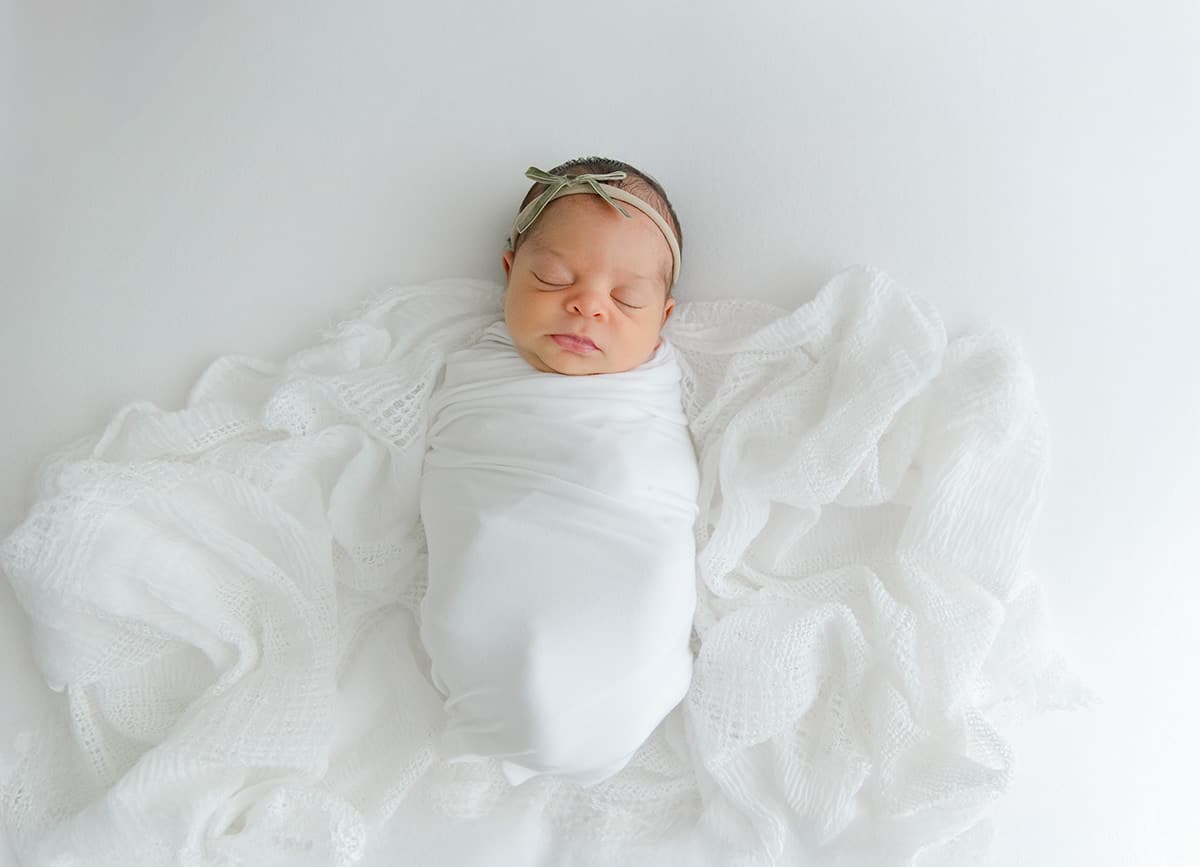 Storkland Pensacola — newborn baby girl swaddled in white wrap at Destin newborn photographer Andrea Krey Photography studio
