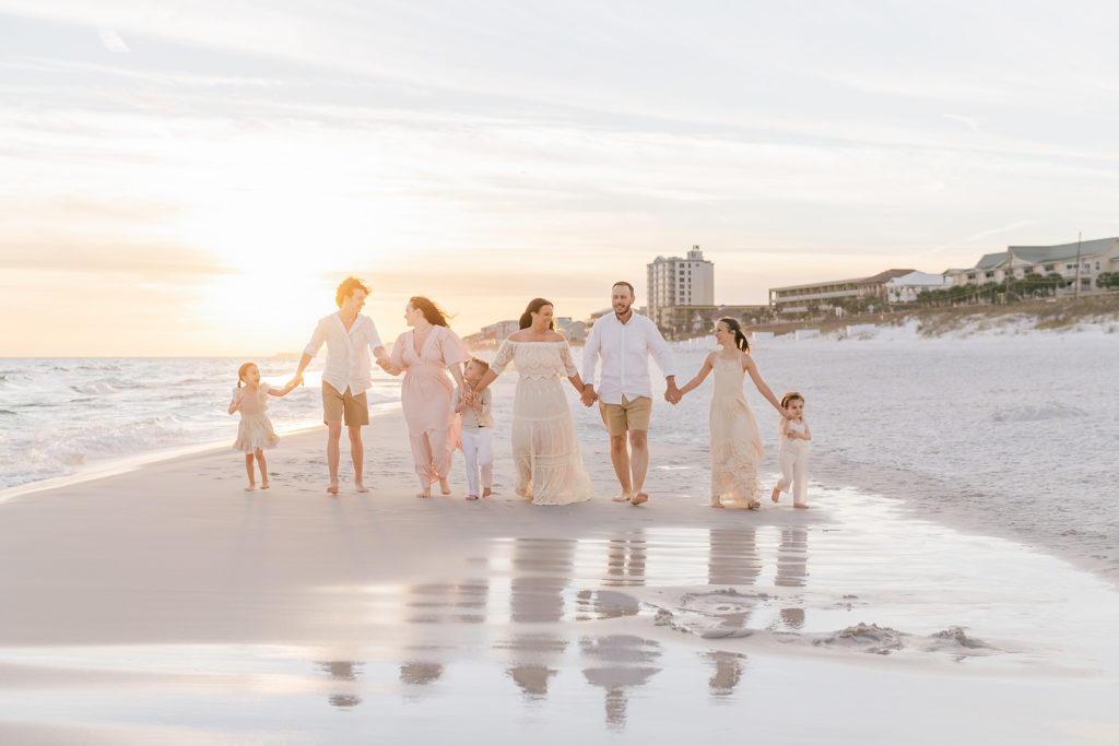 a family holding hands walking along a 30a beach