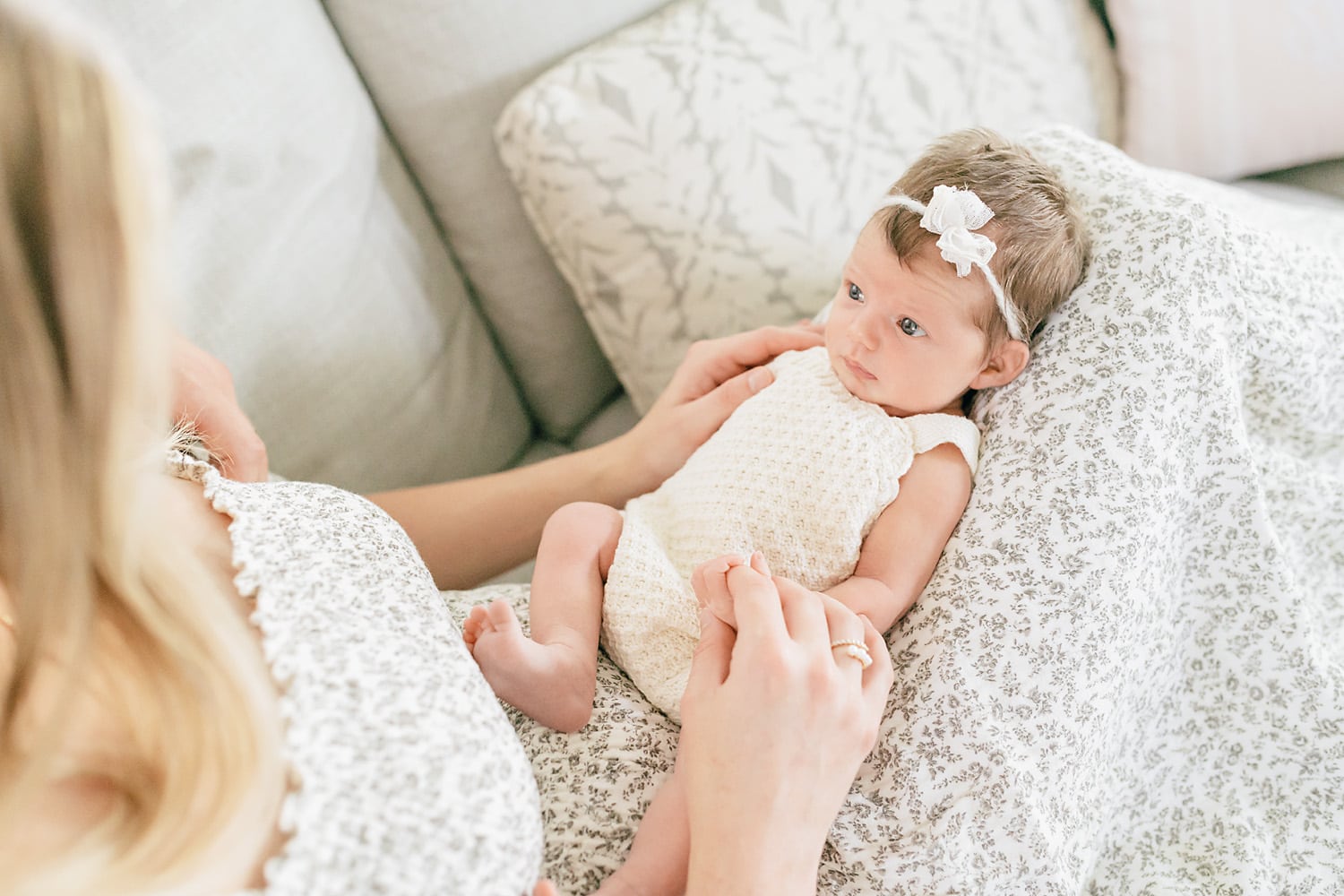 newborn looking at her mother while sitting on a couch