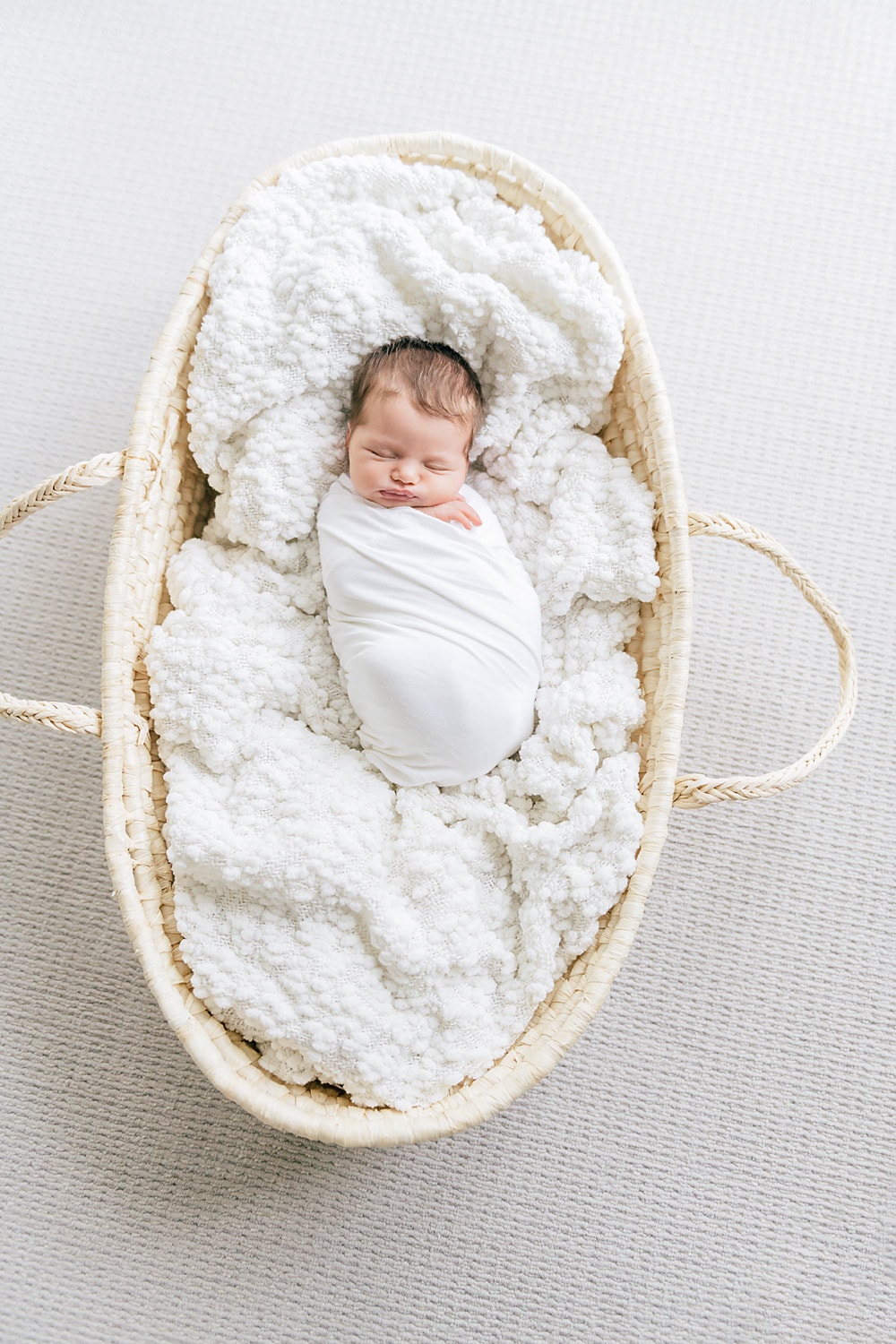 a baby sleeping in a Moses basket by Mobile newborn photographer Andrea Krey