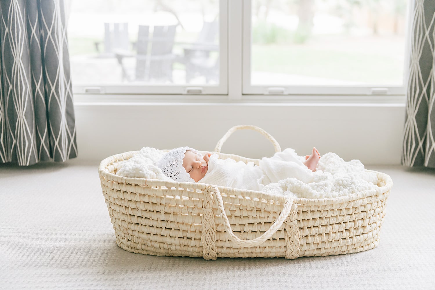 a baby laying in a Moses basket sleeping by Mobile newborn photographer