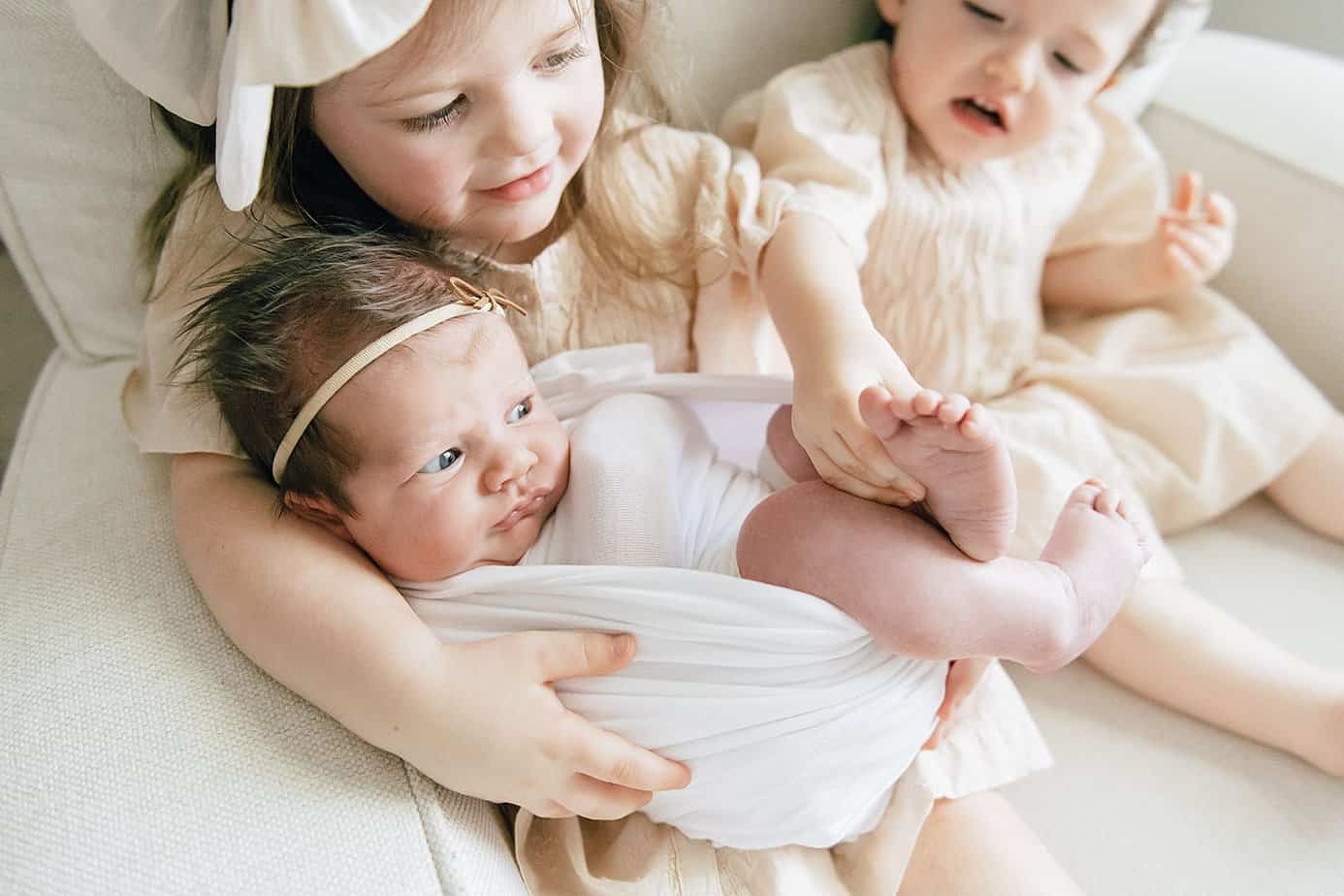 siblings with their newborn at an in-home photography session