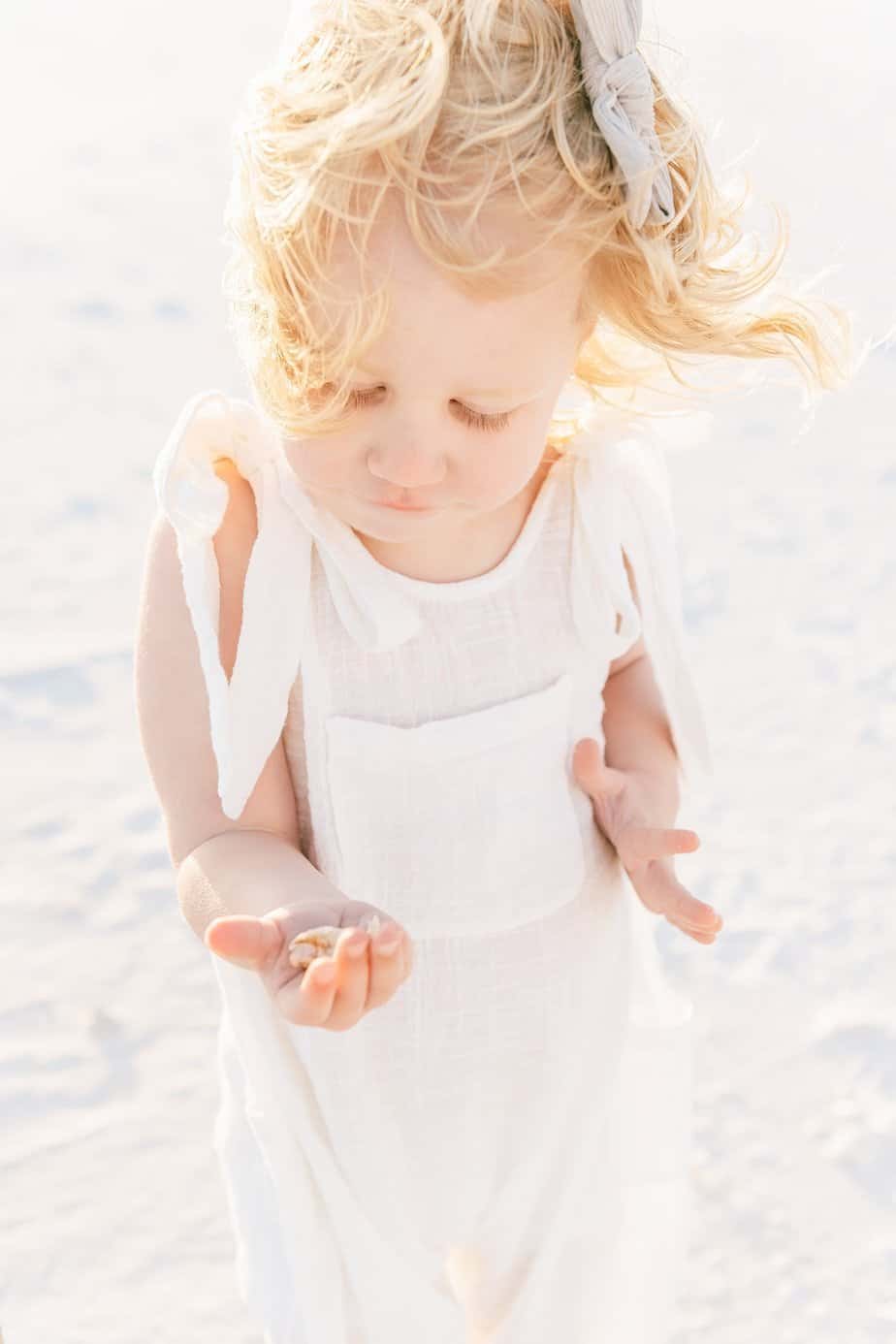 small child with a shell on the beach