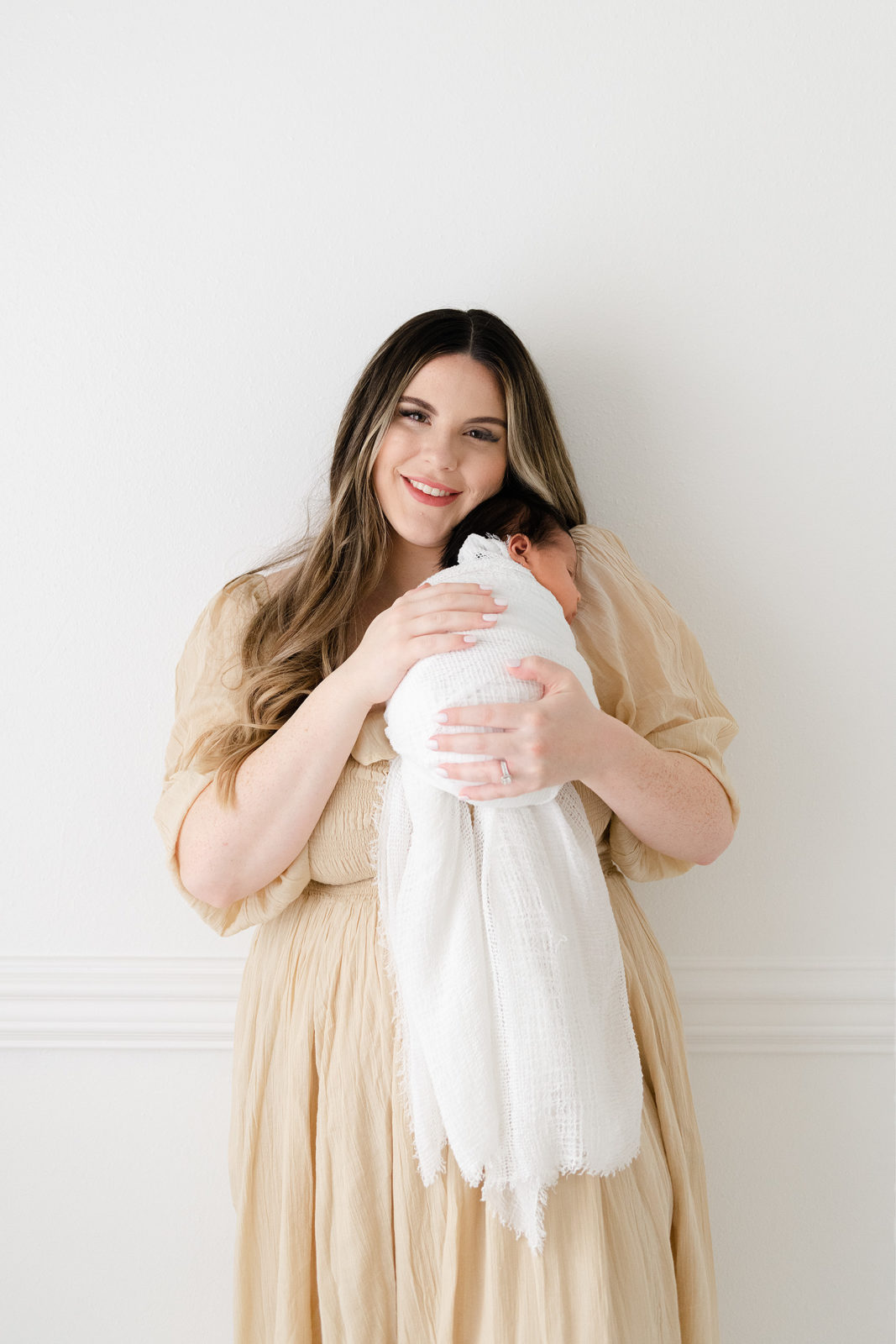 a beautiful woman holding her newborn 