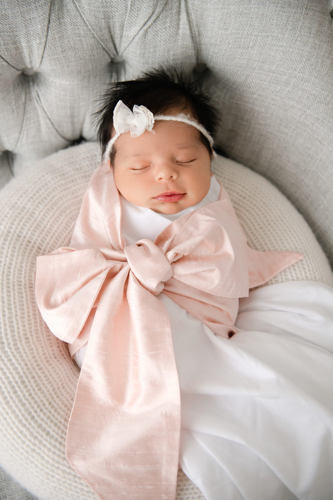 baby wrapped in a pink bow
