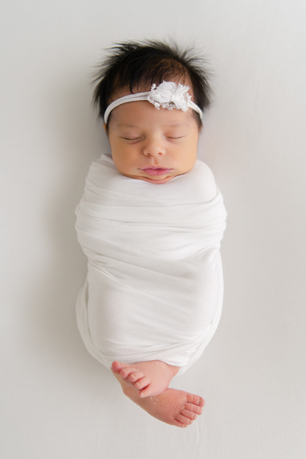 a baby wrapped in a white blanket