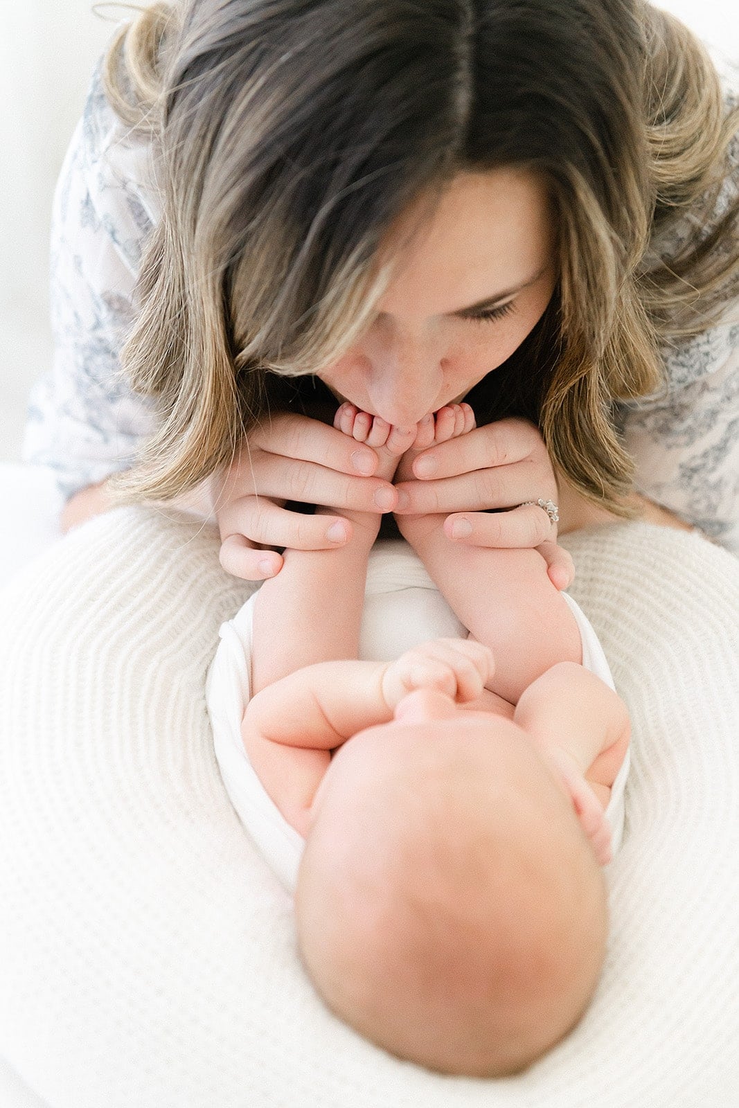 a mother kissing her newborn babies feet Tallahassee photographers