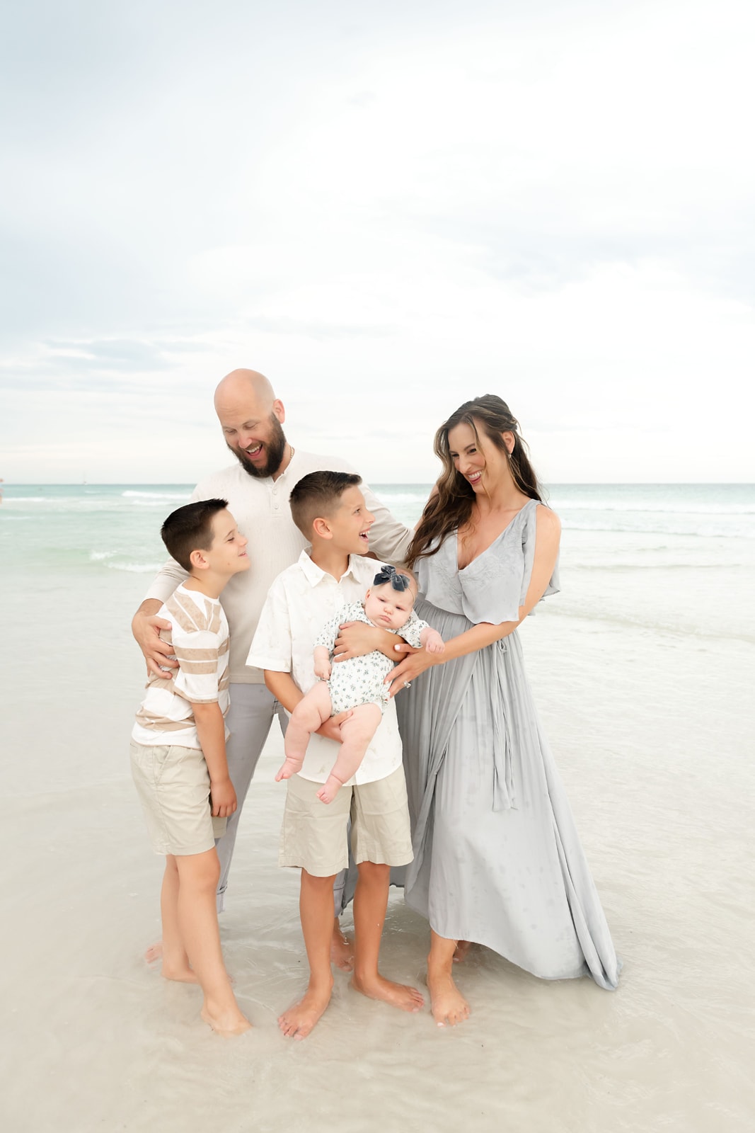A family poses for a family photo on the beach.