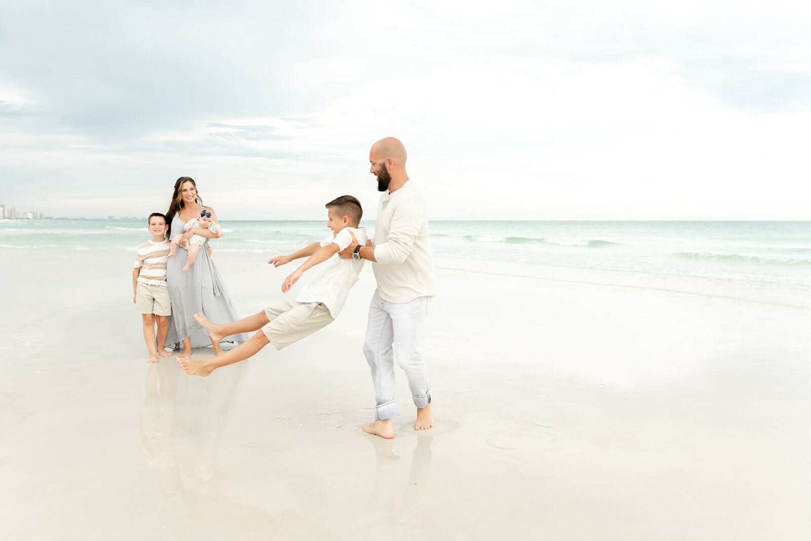 A family is playing on the beach with their children Destin Holiday Isle.