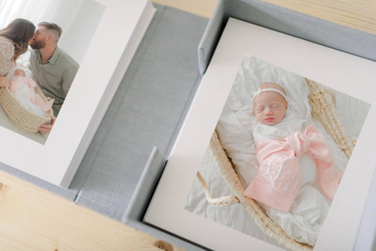 Heirloom newborn photography album and box by Fort Walton Beach newborn photographer Andrea Krey, featuring a sleeping baby girl in a pink monogrammed swaddle