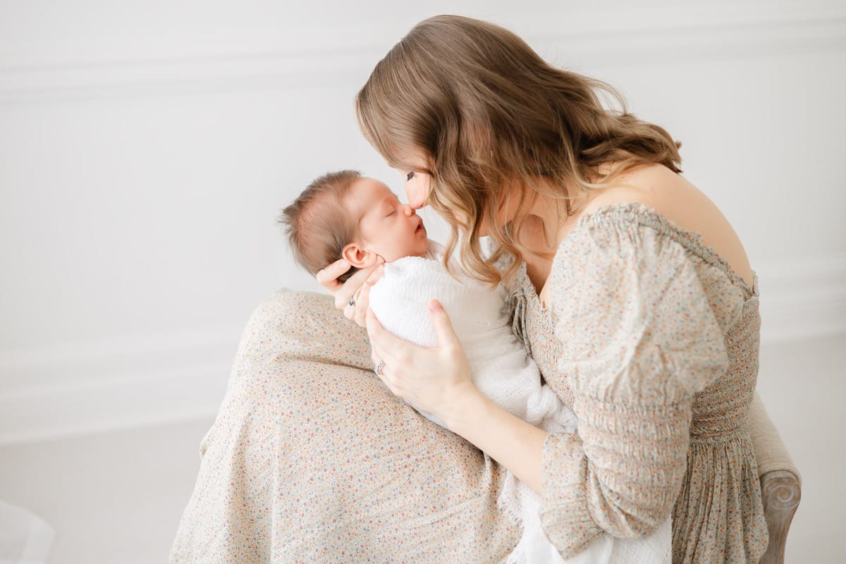Mom gently kissing her newborn baby's nose captured by an Emerald Coast newborn photographer