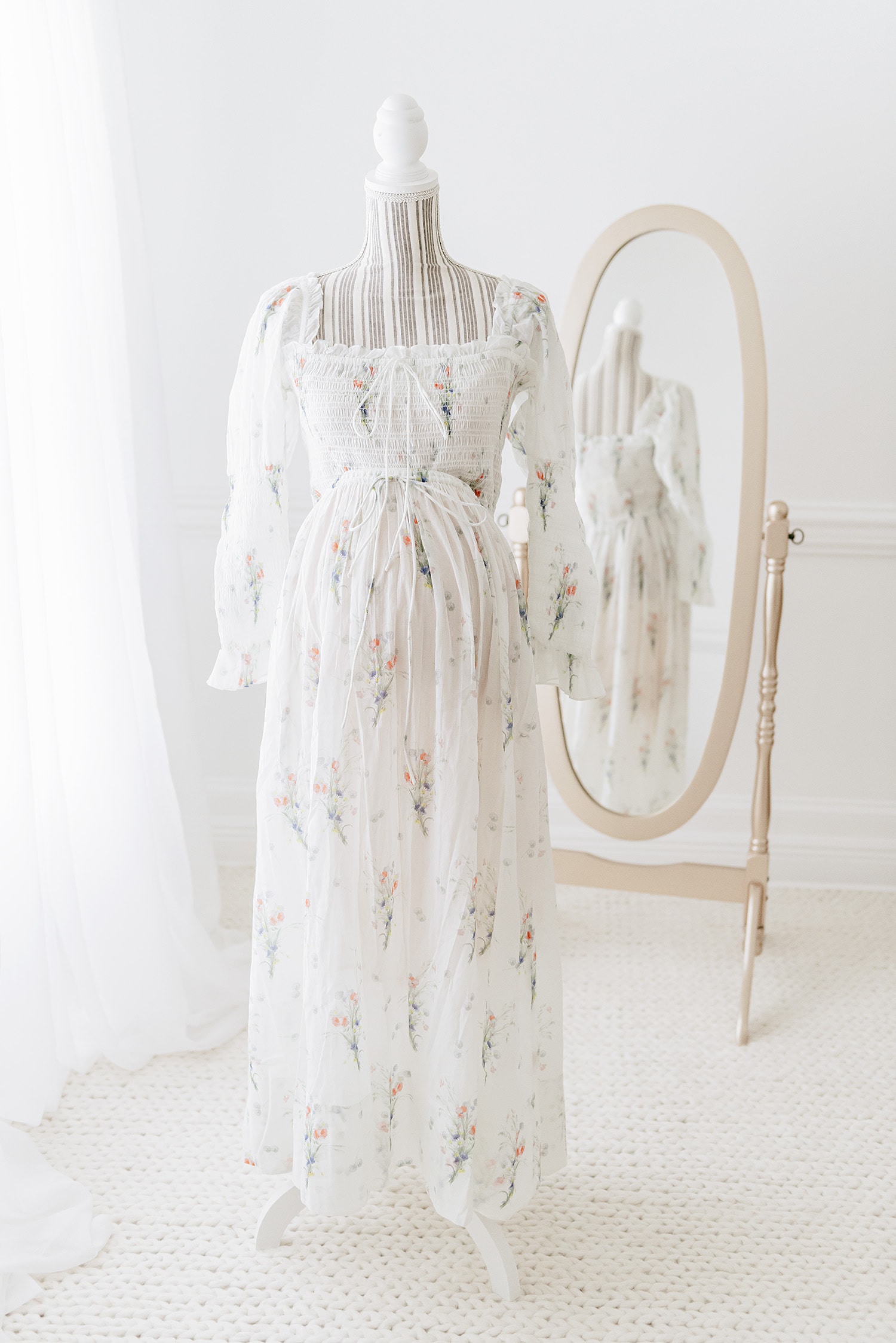 Ivory floral empire waist maternity gown on dress form, showing delicate floral print and ruched waistline, client closet option for what to wear maternity photos Destin beach