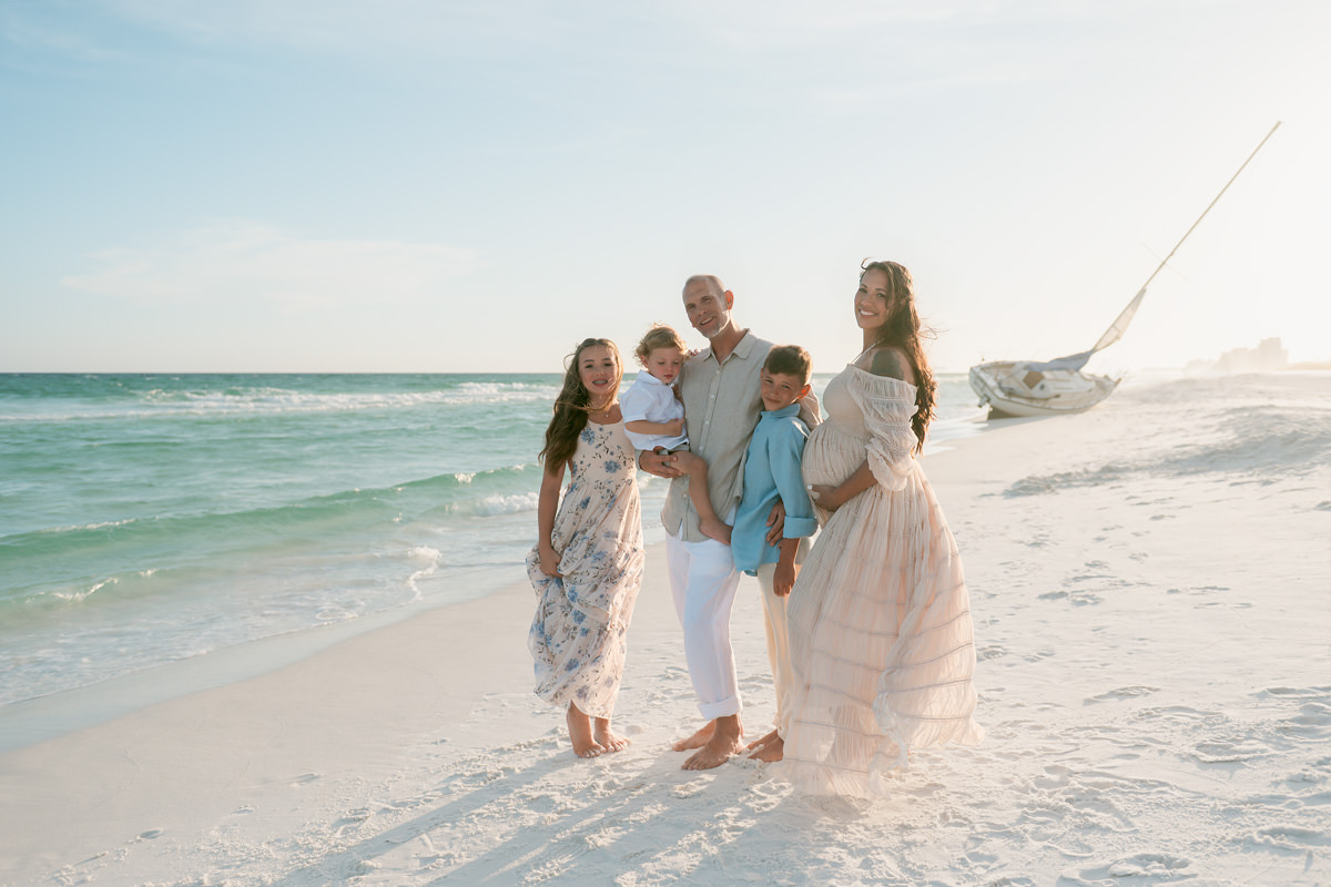 Family in soft blue, cream, and blush outfits with an expecting mom, styled by a personal stylist for photo sessions